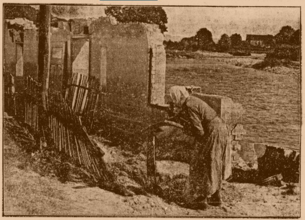 Bäuerin bei ihrem zerstörten Haus